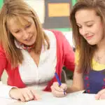Will Tutoring Help with My Children's Grades? 2 tutor from a tutoring franchise helping a girl with SAT prep