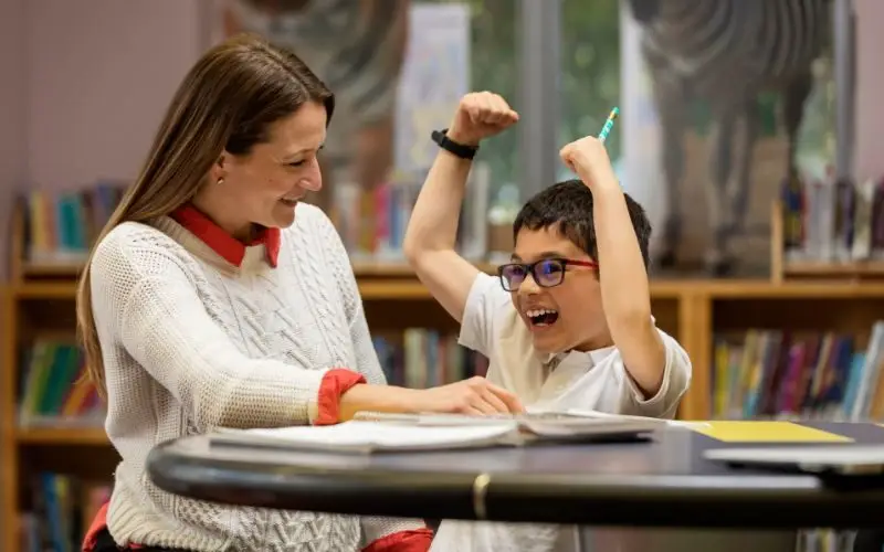 Image-one-child-being-tutord-in-reading-enjoying-many-of-the-tutoring-benefits-at-Kindergarten-and-Beyond-Learning-Center.