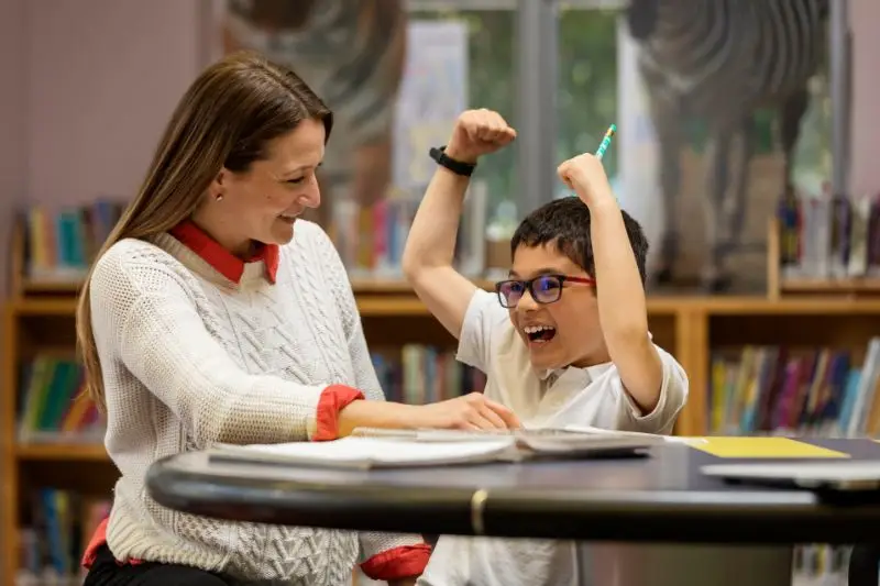 Image-one-child-being-tutord-in-reading-enjoying-many-of-the-tutoring-benefits-at-Kindergarten-and-Beyond-Learning-Center.